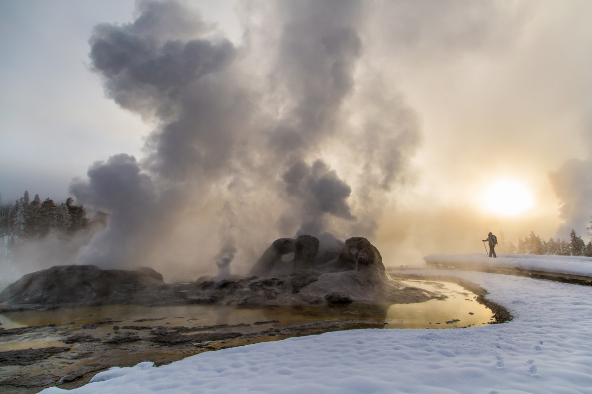 steam erupting from geyser at sunrise