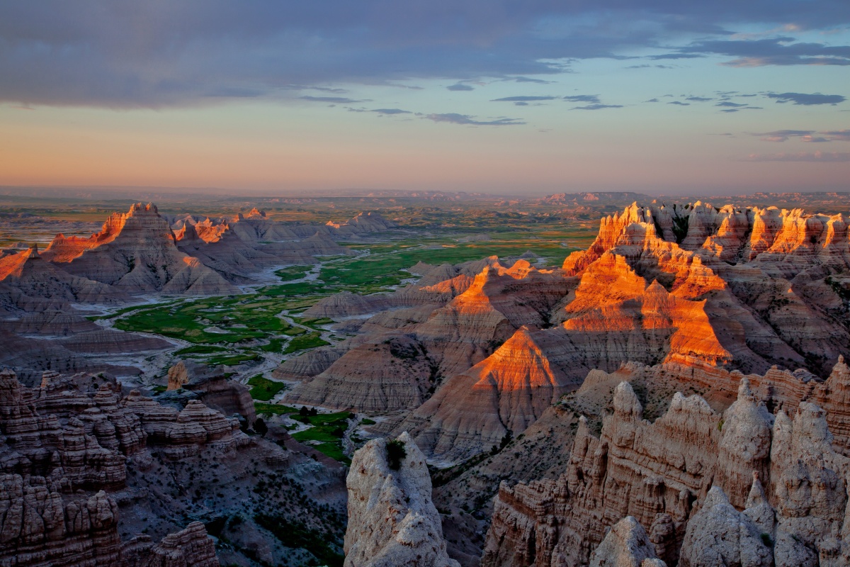The sun sets over the jagged rock formations of the badlands.