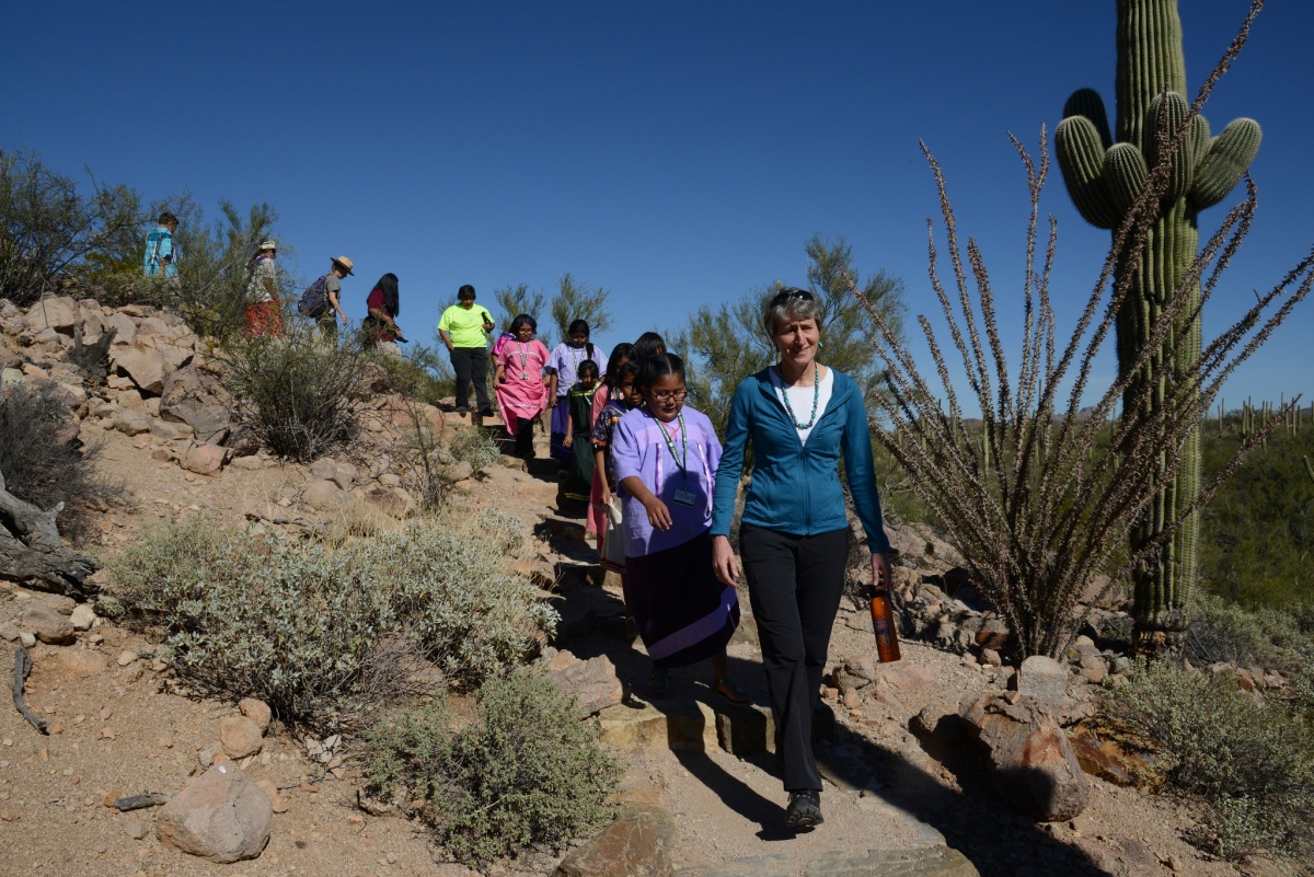Secretary Jewell hiking down a rocky path with Native American students.
