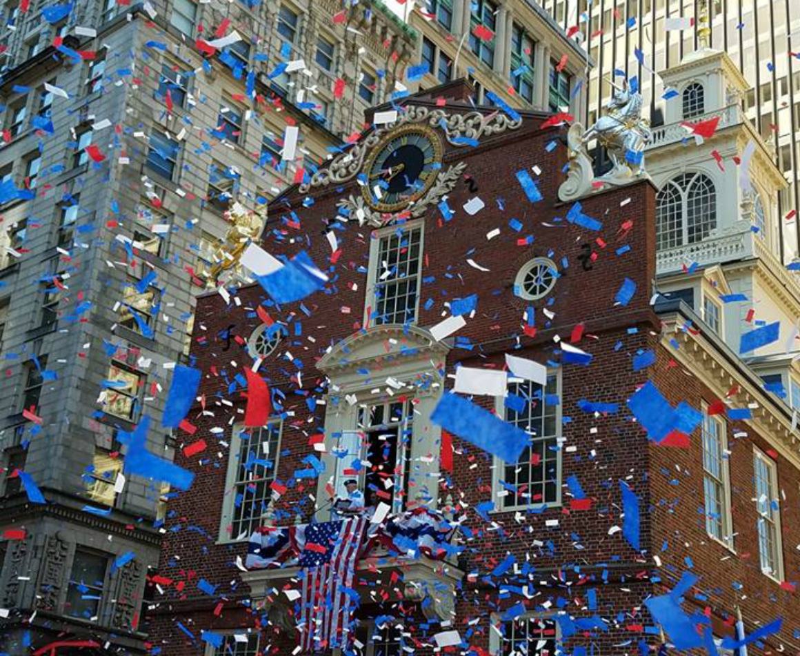Red, blue and white confetti fall around the Boston National Historic Park. 