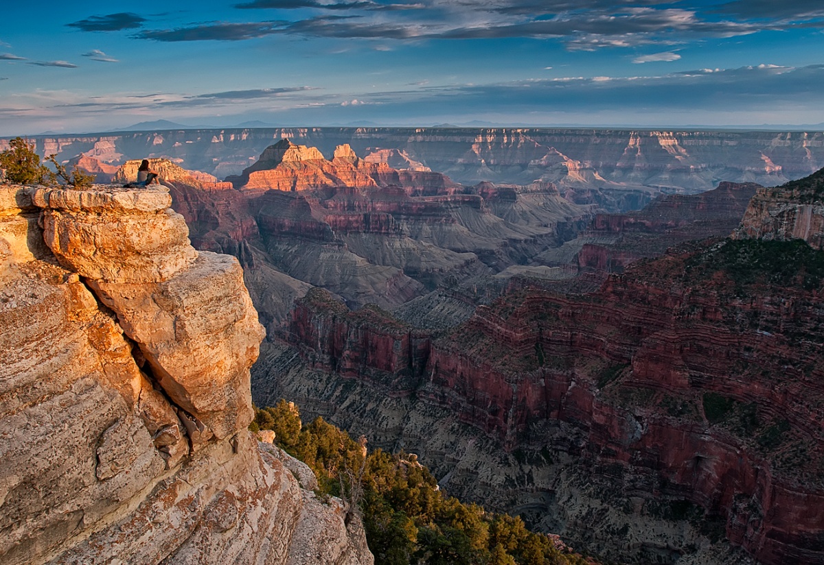 The dark and light layers of the walls of the Grand Canyon shine in fading light.