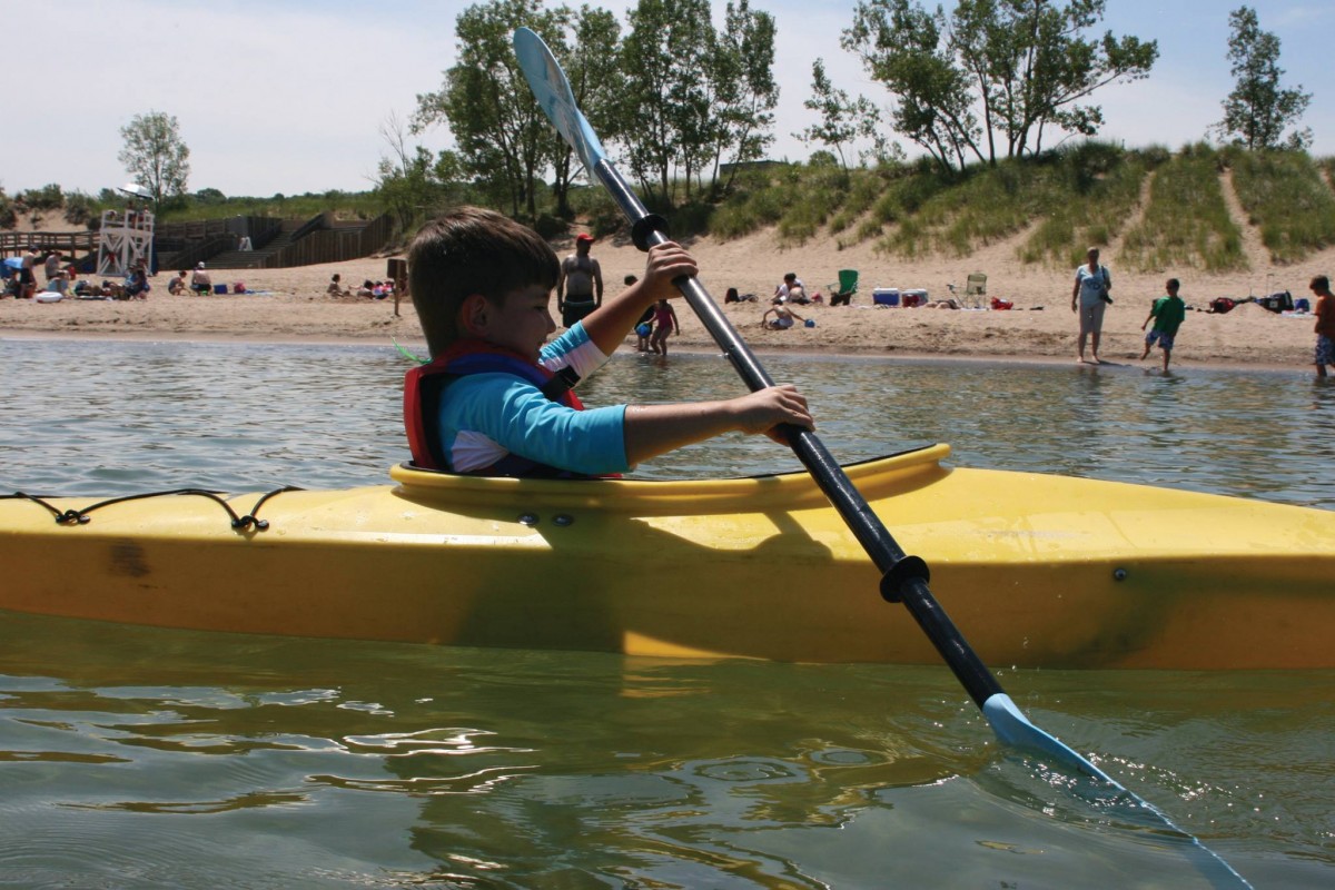 Young boy kayaking in yellow kayak. 
