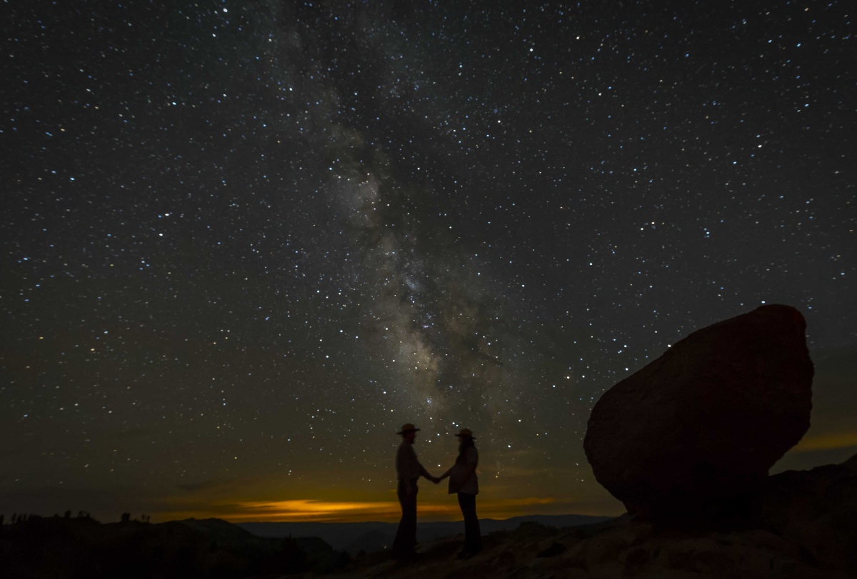 sky full of stars with two people silhouetted