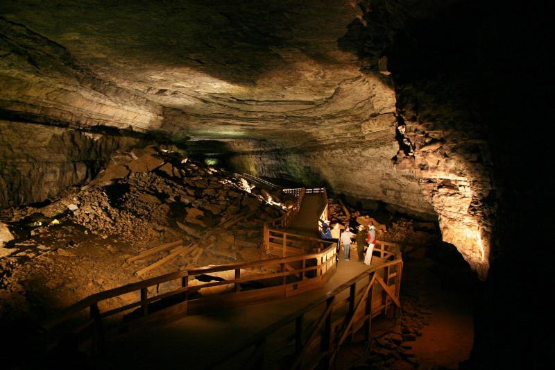 Several tourists walk through the main room of Mammoth Cave