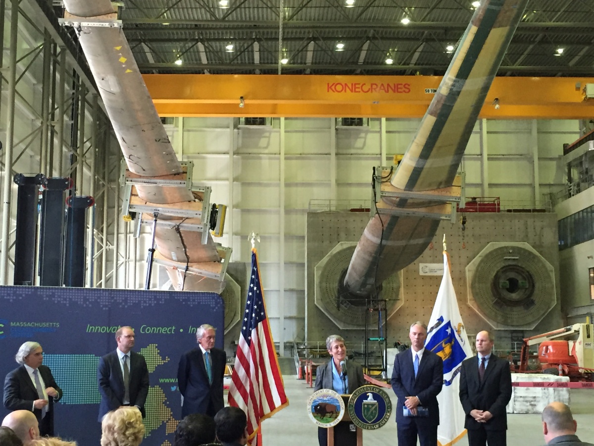 Secretary Jewell speaking with other officials at a en event in a wind turbine testing facility.