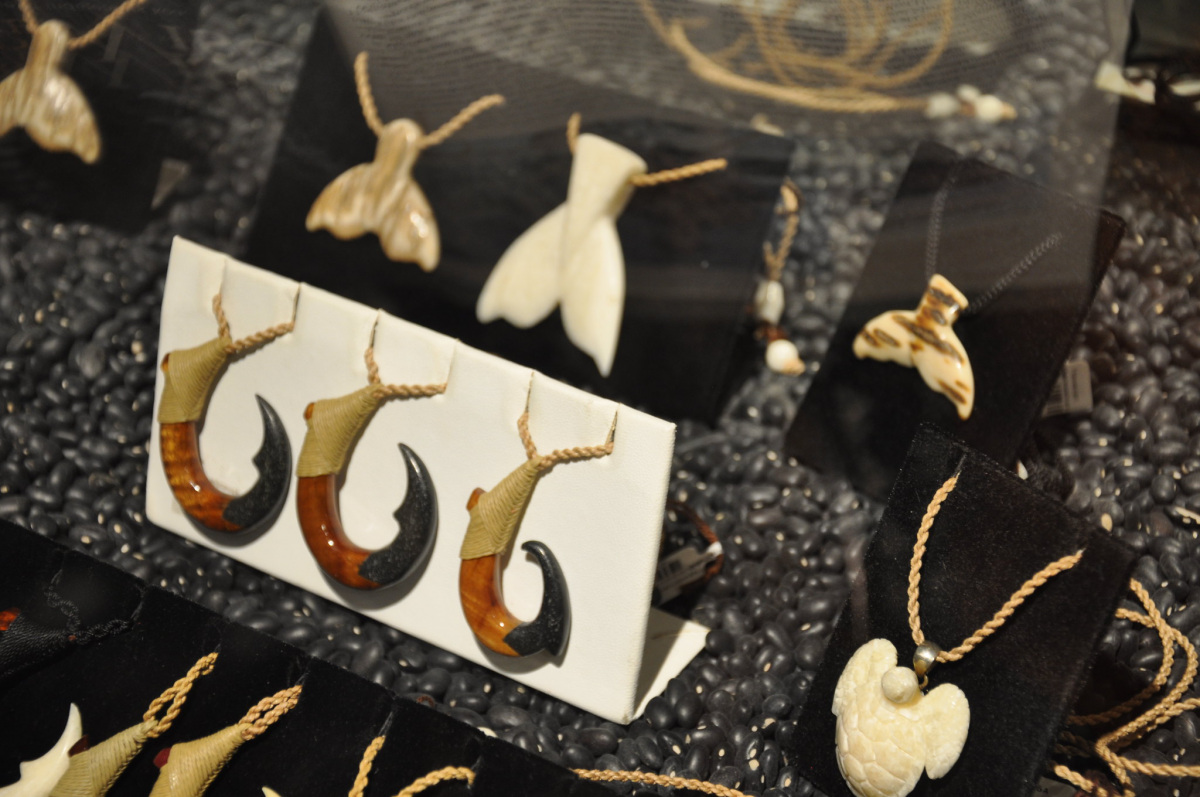 Jewelry carved from ivory, wood and bone sit in a display case.
