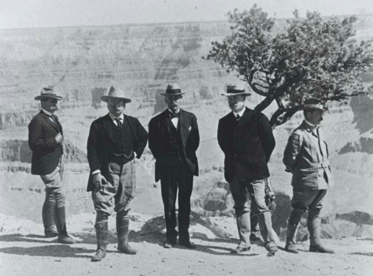 President Theodore Roosevelt and other officials pose in front of the Grand Canyon