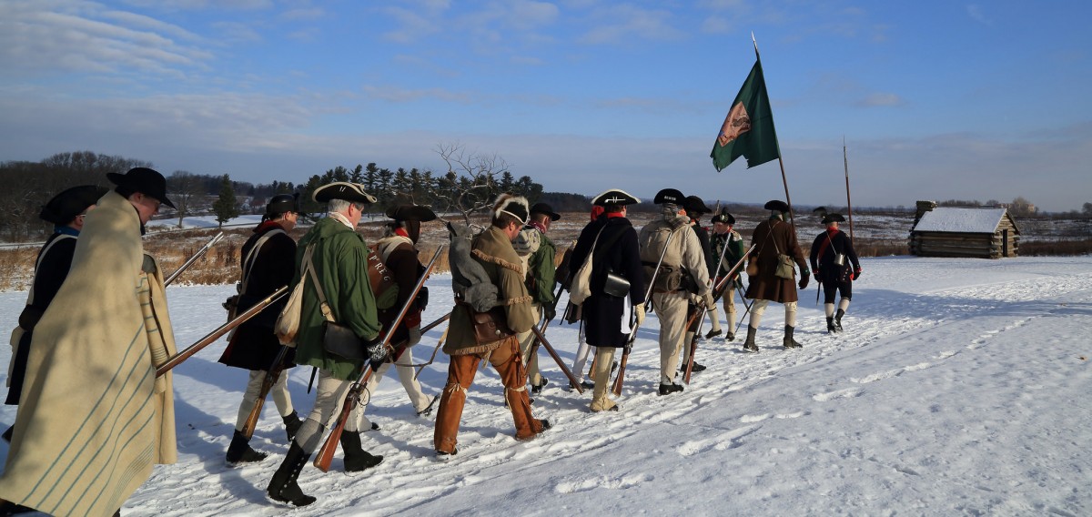 Valley Forge reenactors march through snow. 